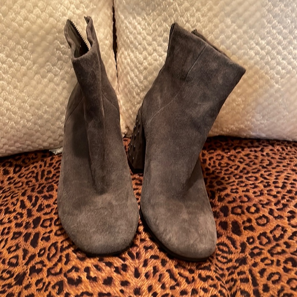 Grey suede booties with heel adorned with silver metal.